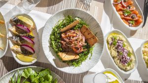 Top-down view of Mediterranean dishes including salads and seafood on an elegant table setting.